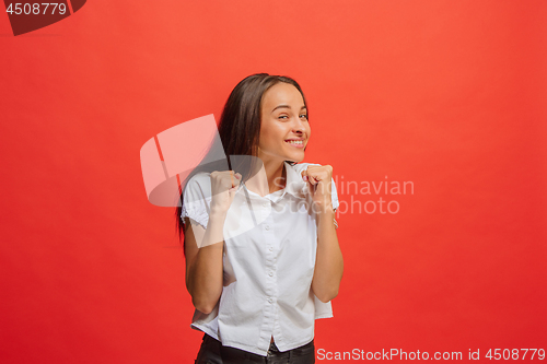 Image of The happy business woman standing and smiling against red background.