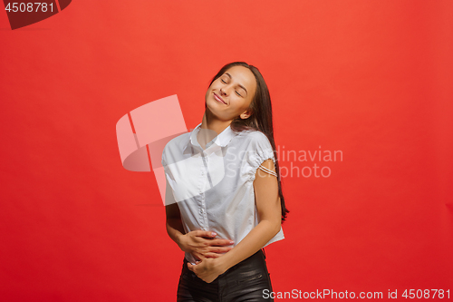 Image of The happy business woman standing and smiling against red background.