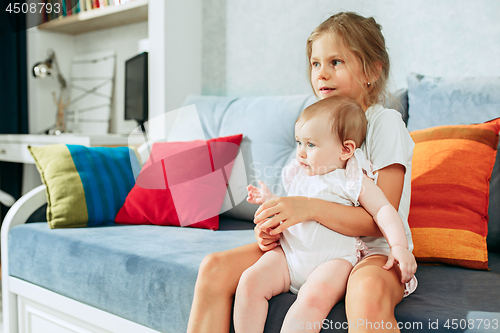 Image of adorable two sisters on bedroom