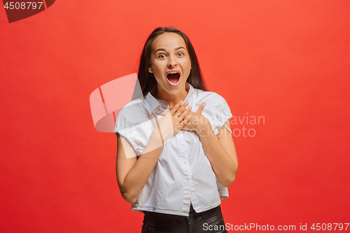 Image of Beautiful woman looking suprised isolated on red