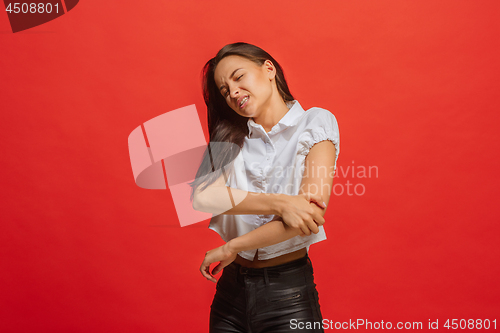 Image of Young woman overwhelmed with a pain in the elbow