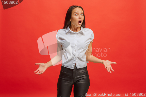 Image of Beautiful woman looking suprised isolated on red