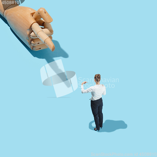 Image of Wooden hand with finger pointing to woman