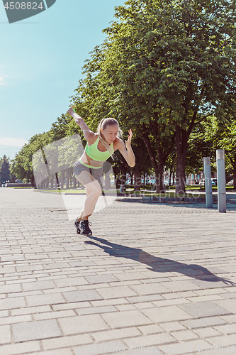 Image of Pretty sporty woman jogging at city