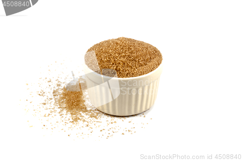Image of Brown cane sugar in ceramic bowl isolated on white background.