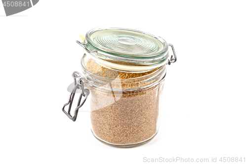 Image of Brown cane sugar in glass jar isolated on white background.