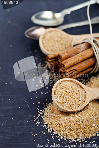 Image of Brown cane sugar, cinnamon sticks and star anise closeup on blac