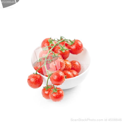 Image of Fresh organic wet cherry tomatoes bunch on ceramic bowl.