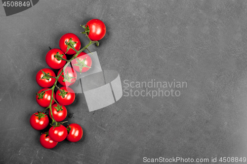 Image of Top view of fresh organic cherry tomatoes bunch on black board