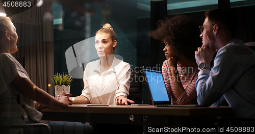 Image of Multiethnic startup business team in night office