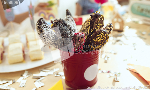 Image of Girl birthday decorations. table setting from above with cakes, drinks and party gadgets.