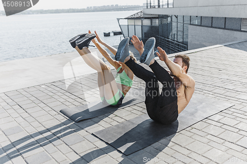 Image of Fit fitness woman and man doing fitness exercises outdoors at city