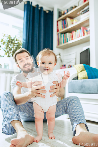 Image of father and his baby daughter at home