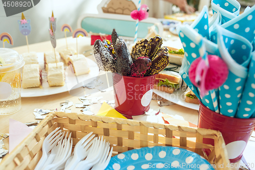 Image of Girl birthday decorations. table setting from above with cakes, drinks and party gadgets.