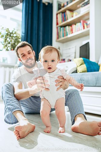 Image of father and his baby daughter at home