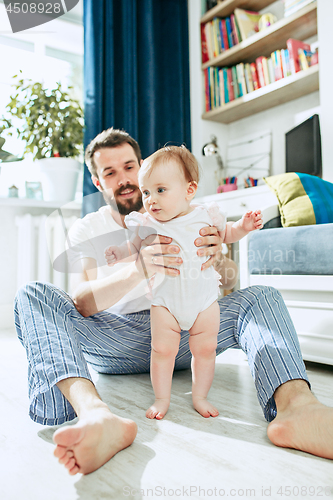 Image of father and his baby daughter at home