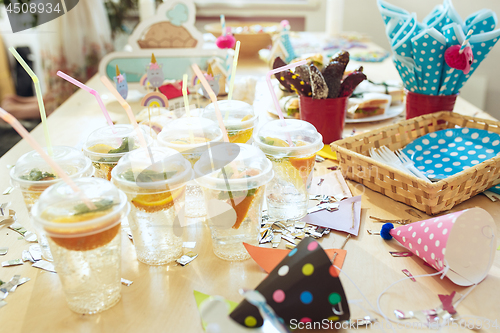 Image of Girl birthday decorations. table setting from above with cakes, drinks and party gadgets.