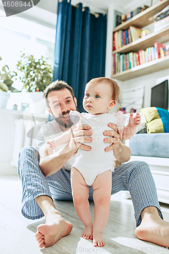 Image of father and his baby daughter at home