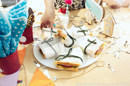 Image of Girl birthday decorations. table setting from above with cakes, drinks and party gadgets.