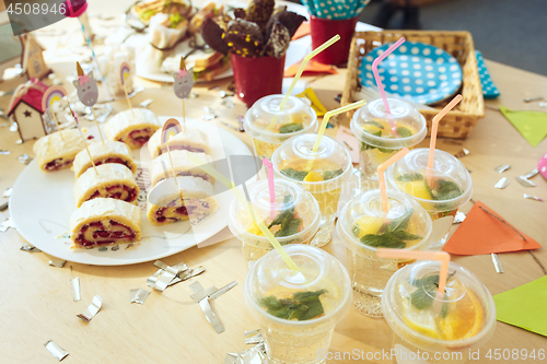 Image of Girl birthday decorations. table setting from above with cakes, drinks and party gadgets.