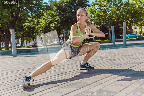 Image of Fit fitness woman doing stretching exercises outdoors at park