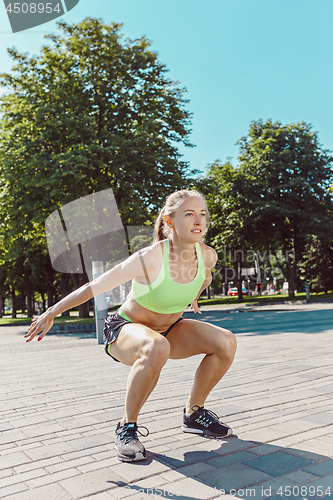 Image of Fit fitness woman doing stretching exercises outdoors at park