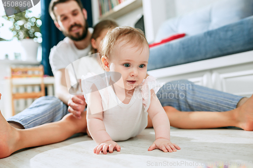 Image of Proud father holding his newborn baby daughter at home