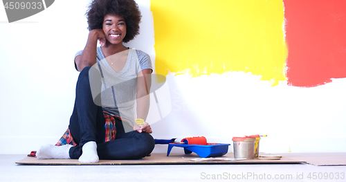 Image of black female painter sitting on floor