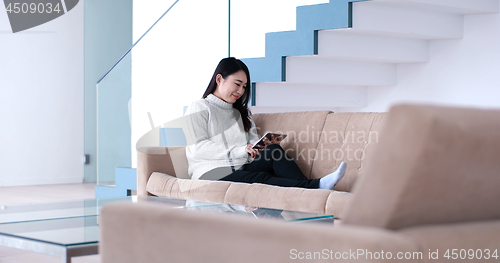 Image of asian woman using Digital Tablet on sofa