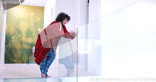 Image of young man using a tablet at home