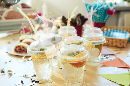 Image of Girl birthday decorations. table setting from above with cakes, drinks and party gadgets.