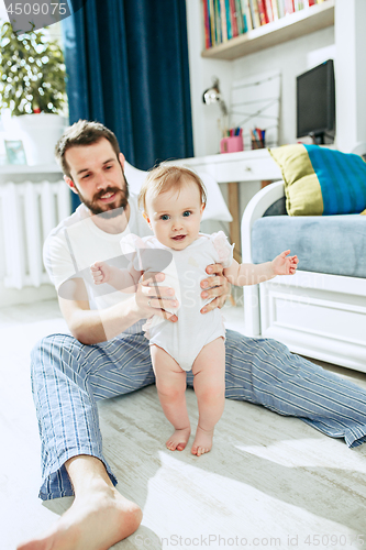 Image of father and his baby daughter at home