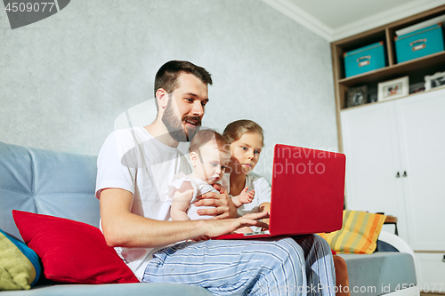 Image of father and his daughters at home