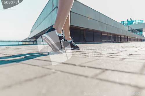 Image of Pretty sporty woman jogging at city