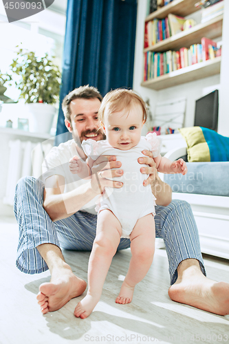 Image of father and his baby daughter at home