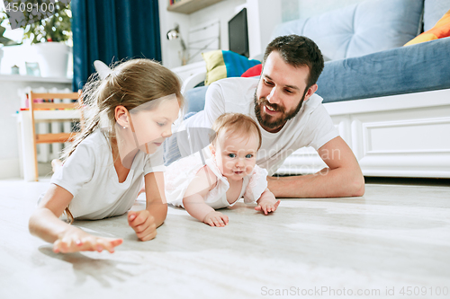 Image of Proud father holding his newborn baby daughter at home