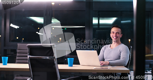 Image of man working on laptop in dark office