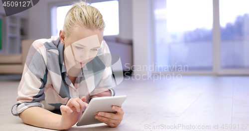 Image of young women using tablet computer on the floor