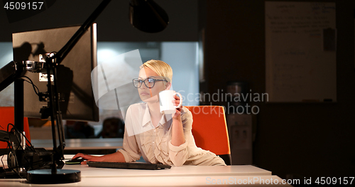 Image of woman working on computer in dark office