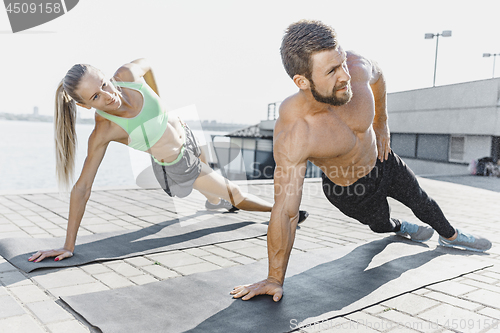 Image of Fit fitness woman and man doing fitness exercises outdoors at city