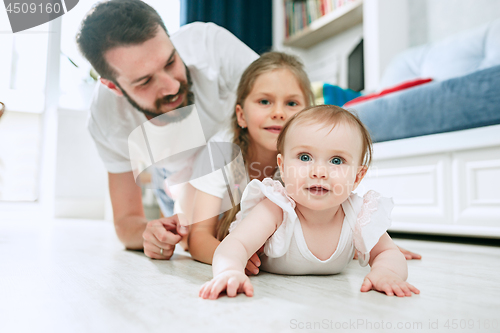 Image of Proud father holding his newborn baby daughter at home