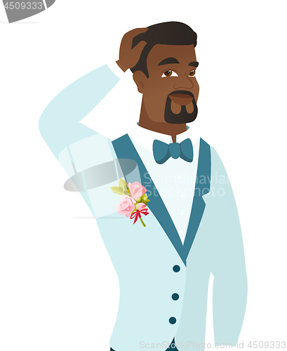 Image of Young african-american groom scratching his head.