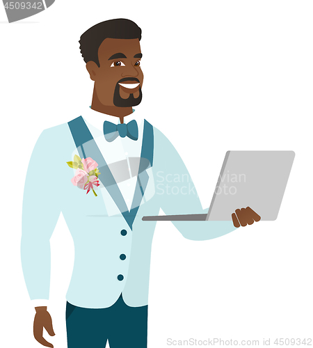 Image of Young african-american groom using a laptop.