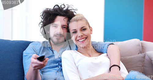 Image of Young couple on the sofa watching television