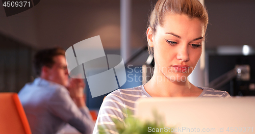 Image of woman using mobile phone in dark office