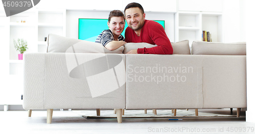 Image of Young couple on the sofa watching television