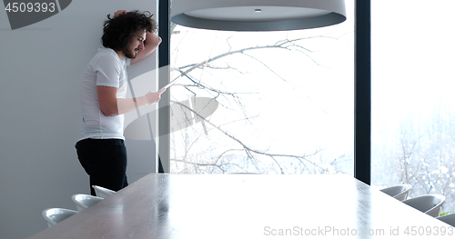 Image of young man using a tablet at home