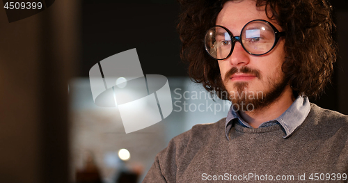 Image of man working on computer in dark office