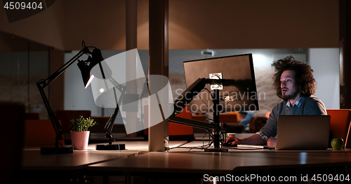 Image of man working on computer in dark office