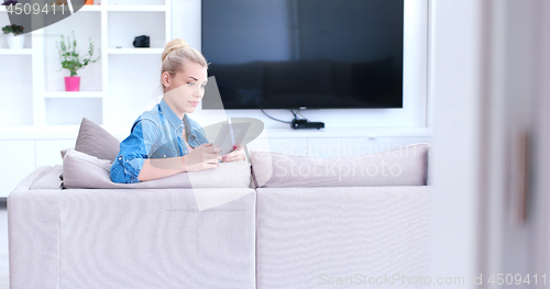 Image of woman on sofa using tablet computer